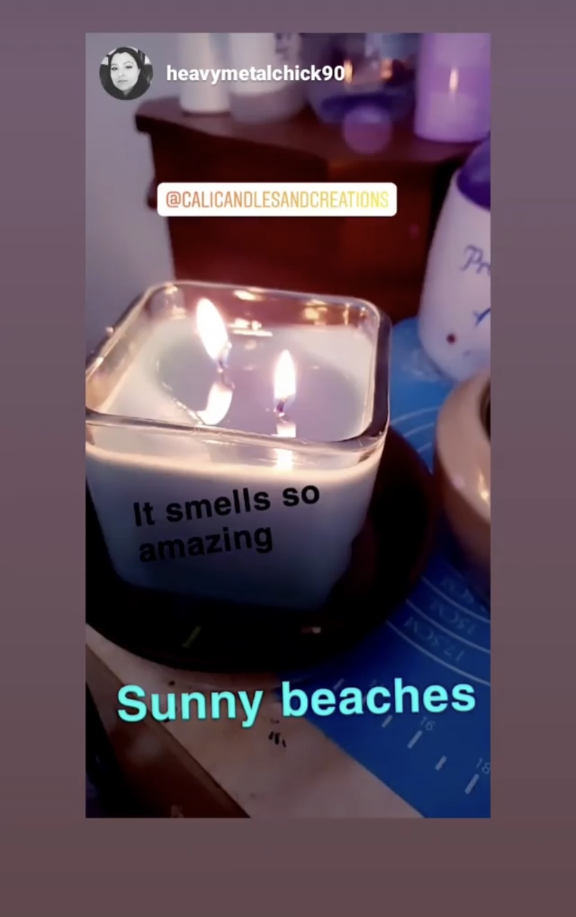 A lit Sunny Beaches candle burning on a table